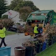 WM Garbage Truck Packing A Masive Yard Waste Pile